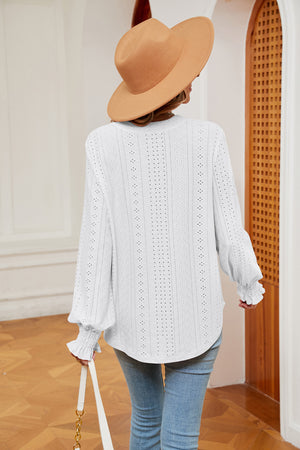 White eyelet blouse with poet sleeves and ruffled cuffs.