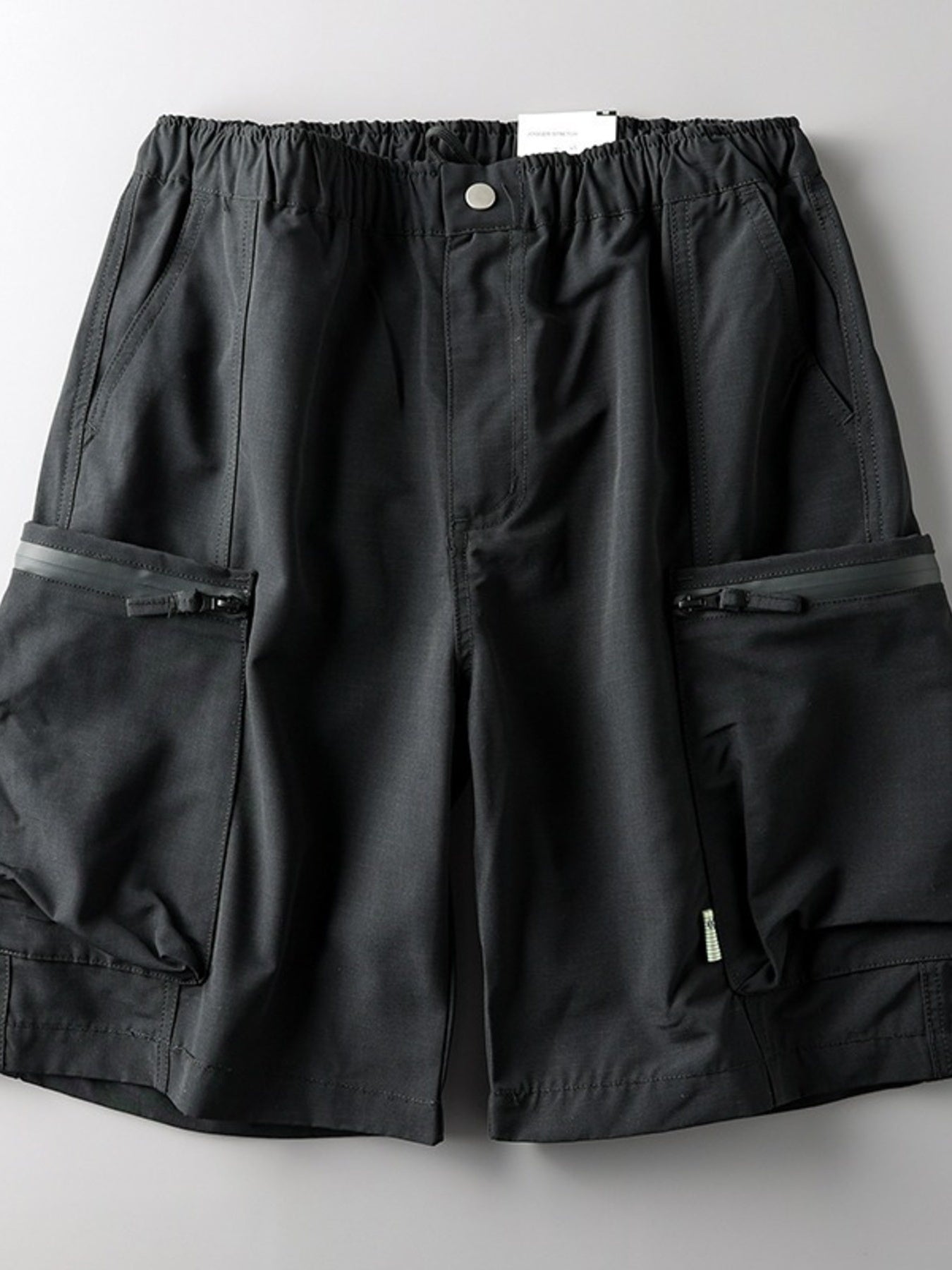 Black relaxed fit cargo shorts with zippered pockets and elastic waistband.