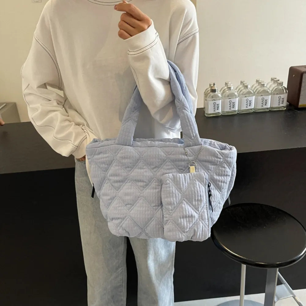 Quilted shopper bag in light blue with diamond pattern and front pocket.