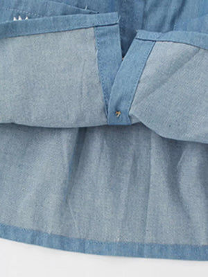 Light wash denim baby dress with button front detail and embroidered accents.