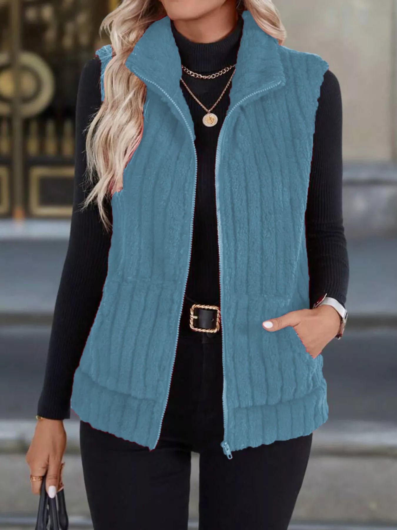 Sky blue fleece zip-up vest with pockets and a stand-up collar.