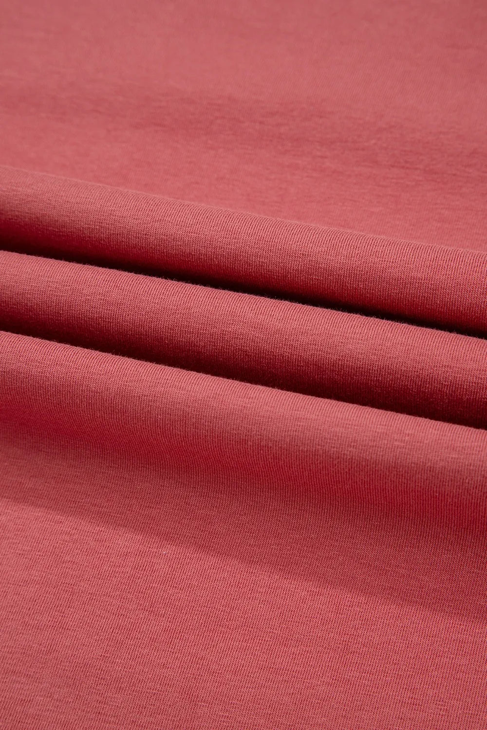 Burnt coral t-shirt fabric with a soft, textured knit detail