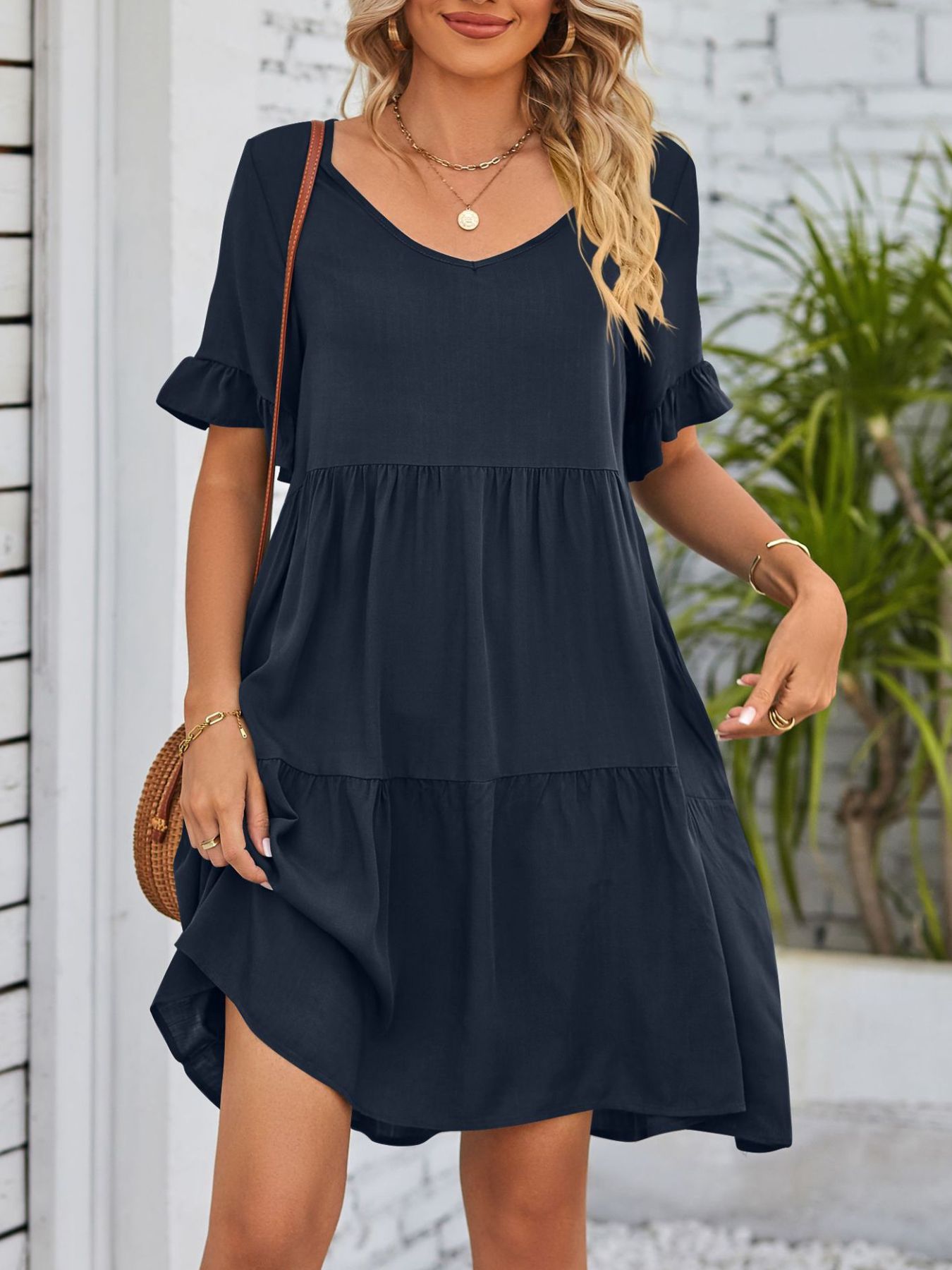 Navy tiered mini dress with v-neck and ruffled short sleeves.