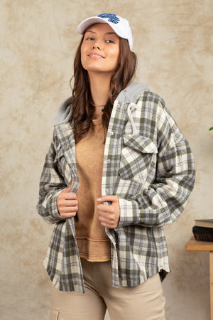 Cozy plaid shacket with sherpa hood in Sage, featuring buttoned pockets and a casual fit.