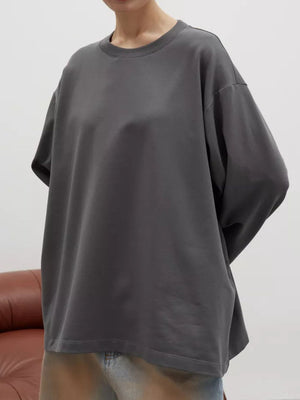Oversized crewneck sweatshirt in dark gray with voluminous sleeves and a relaxed fit.