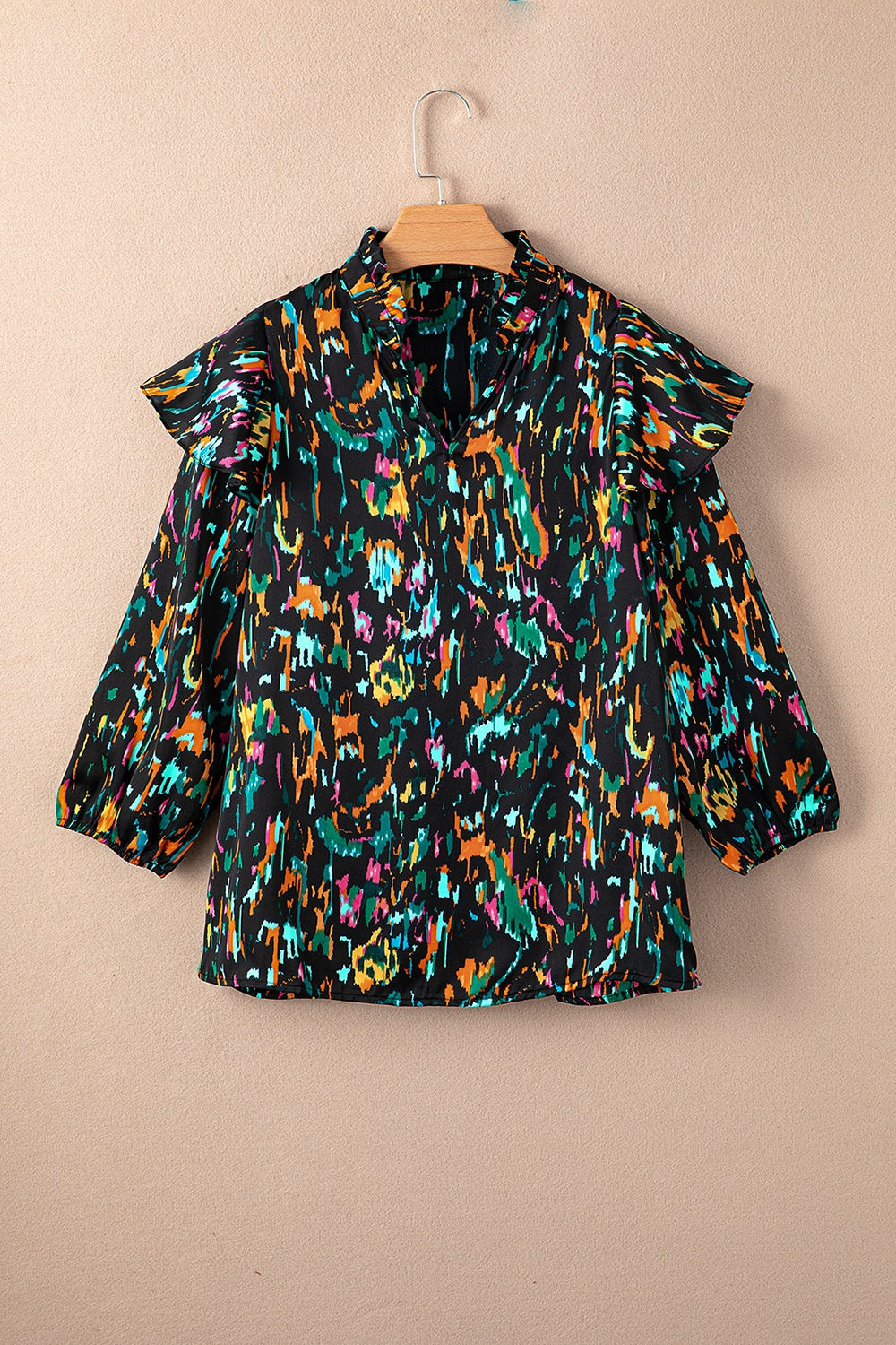 Black abstract print blouse with ruffled aura sleeves and a mock neck.