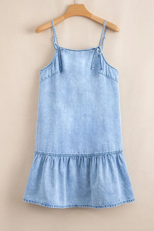Light blue denim sundress with tie straps and ruffled hem.