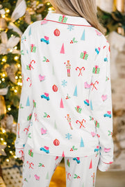 White pajama set with festive holiday print, piping, and collar.