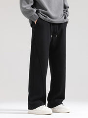 Men's black wide-leg sweatpants with drawstring waist and seam detail.