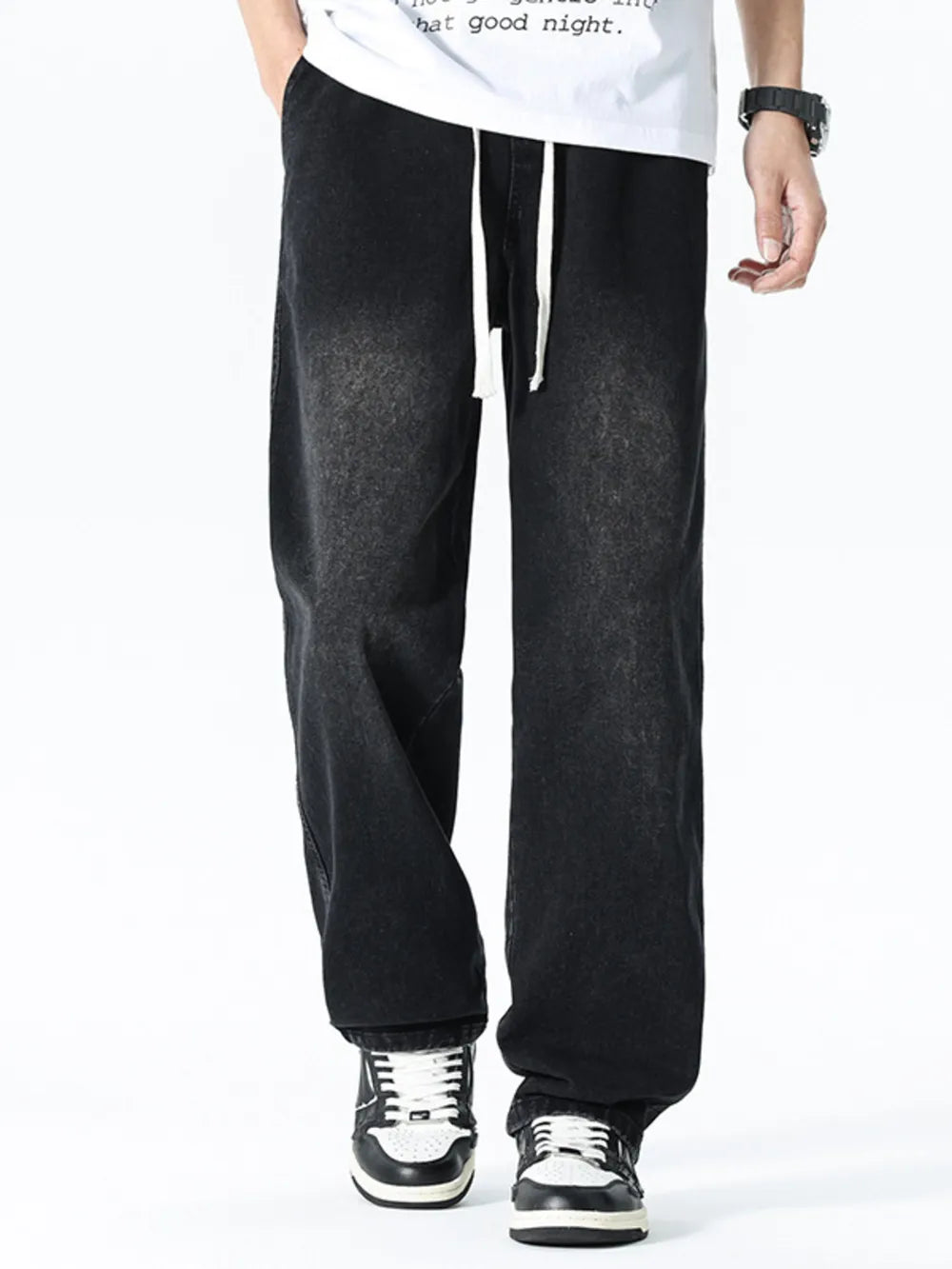 Relaxed wide leg black denim jeans with white drawstring detail.
