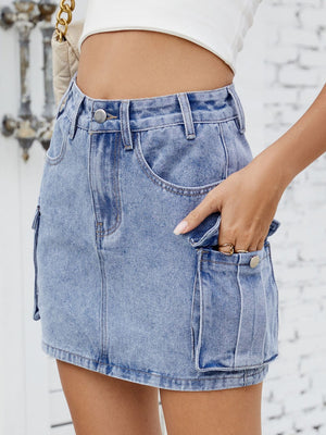 Denim cargo mini skirt in medium blue with button closure and utility pockets.