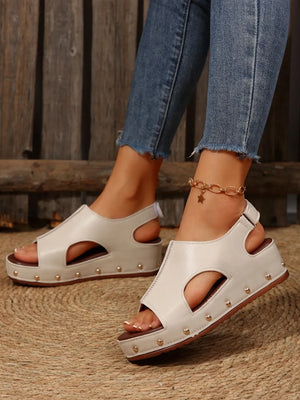 Beige cutout studded platform sandals with open toe and ankle strap.