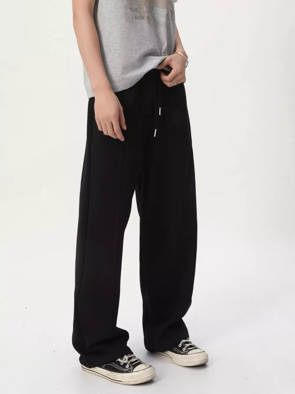 Men's black cotton wide-leg drawstring sweatpants with stitched seams.