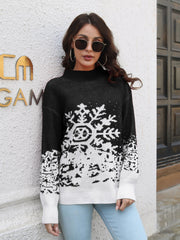 Black acrylic mock neck sweater with large white snowflake intarsia pattern.