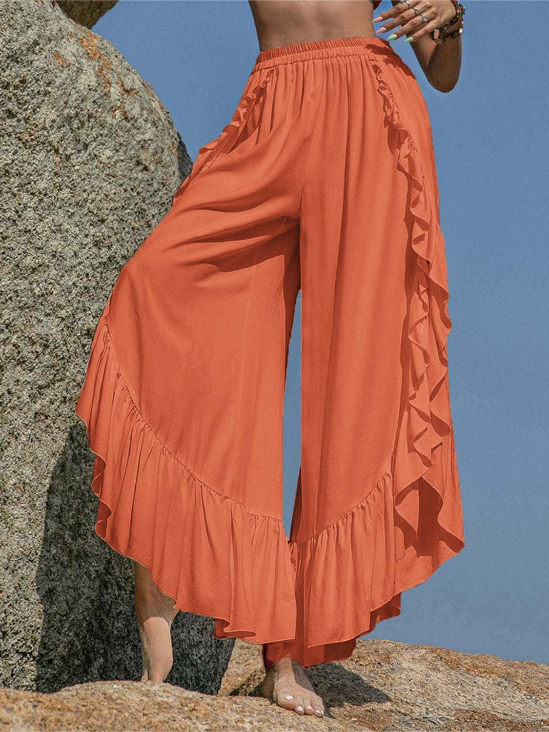 Ochre palazzo pants with ruffled hemline and split legs, styled for a boho chic look.
