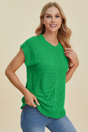 Green knit patchwork top with cable and diamond stitch details, short sleeves.