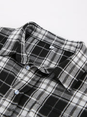Oversized black and white plaid button-up shirt with collar and light blue buttons.