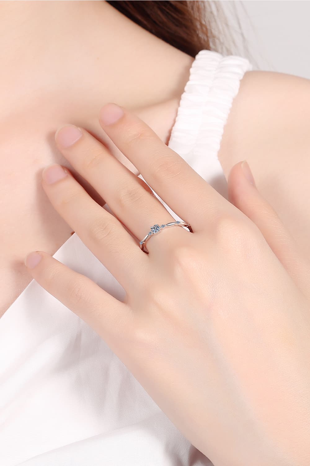 Delicate silver band ring with small diamonds and scalloped details.