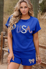Royal blue textured USA tee and bow shorts set with patriotic USA graphic on tee and bow detail on shorts.