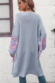 Cloudy Blue acrylic cardigan with textured sleeves and colorful fringe detail.