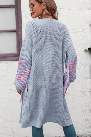 Cloudy Blue acrylic cardigan with textured sleeves and colorful fringe detail.
