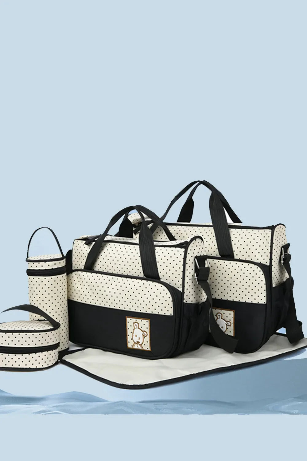 Polka dot diaper bag set in black and cream with embroidered animal detail.