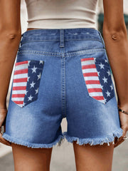Distressed denim shorts with American flag pocket details and frayed hem.