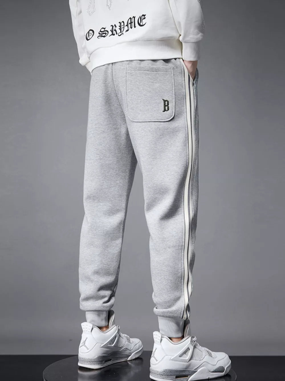 Light gray cotton joggers with side stripe detail and cuffed ankles.