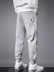Light gray cotton joggers with side stripe detail and cuffed ankles.