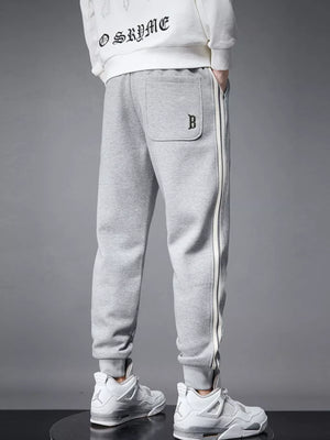 Light gray cotton joggers with side stripe detail and cuffed ankles.