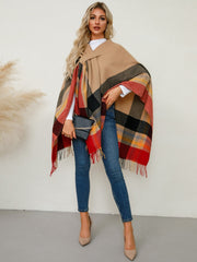 Asymmetric plaid cape in tan with red, black, and yellow checkered pattern and fringe detail.