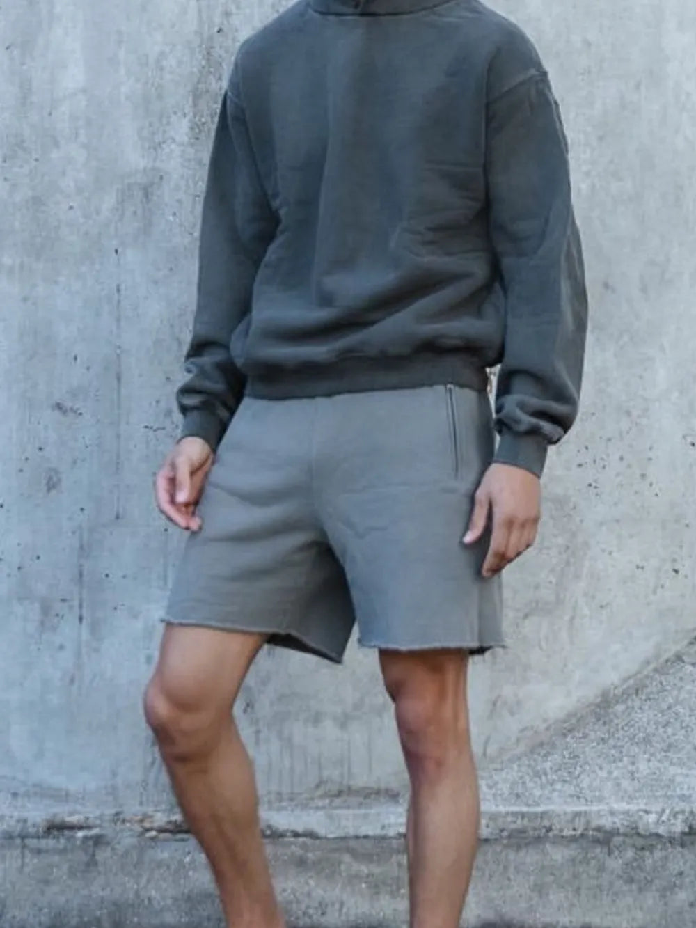 Gray relaxed fit shorts with raw hem and side pockets.