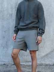 Gray relaxed fit shorts with raw hem and side pockets.