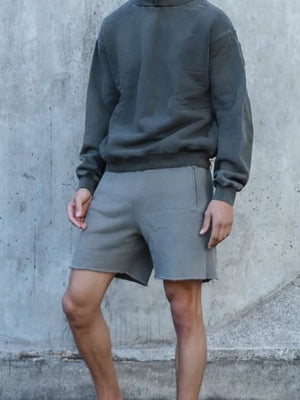 Gray relaxed fit shorts with raw hem and side pockets.