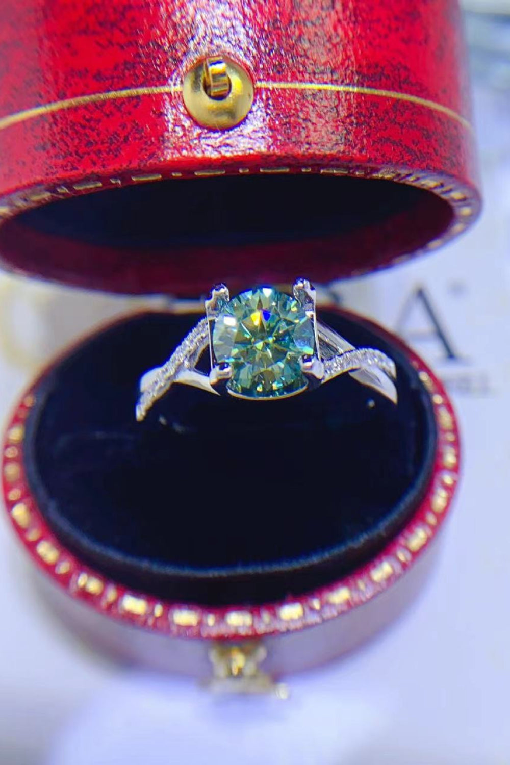Veridian Halo Sterling Ring with light green stone and diamond band in red box