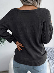Charcoal cable-knit sweater with buttoned shoulder detail and raglan sleeves.