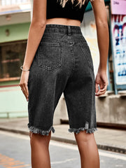 Black denim cutoff shorts with distressed hem and knee details.