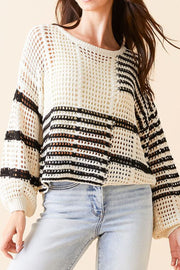 White crochet knit pullover with black graphic stripes and balloon sleeves.