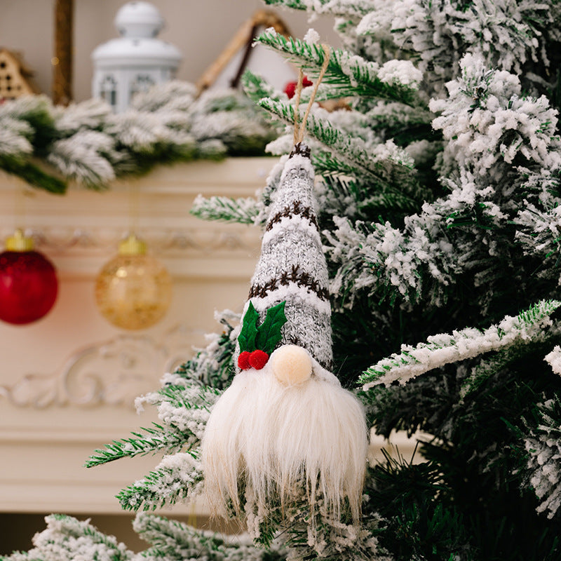 Knitted gnome ornament with gray, white, and brown stripes, white beard, and red berries.