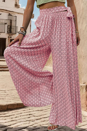 Pink geometric print wide-leg palazzo trousers with a tie waist detail.