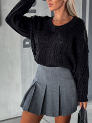 Black cable knit V-neck sweater with relaxed fit and textured pattern.