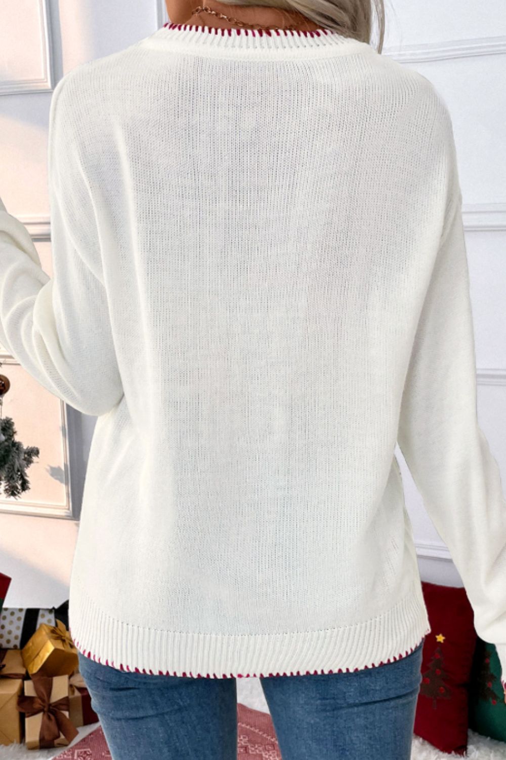 White acrylic knit sweater with festive red trim on neckline and hem.