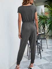 Dark gray jersey jumpsuit with drawstring waist, short sleeves, and cuffed ankles.