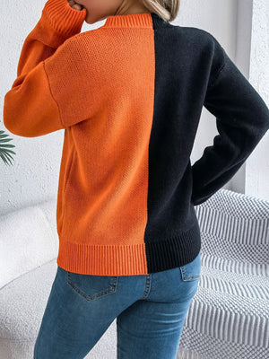 Split-face orange and black knit sweater with ribbed cuffs and hem.