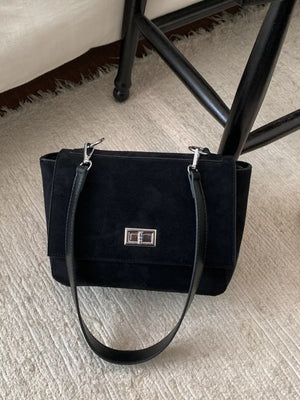 Black suede crossbody bag with flap closure and silver hardware.