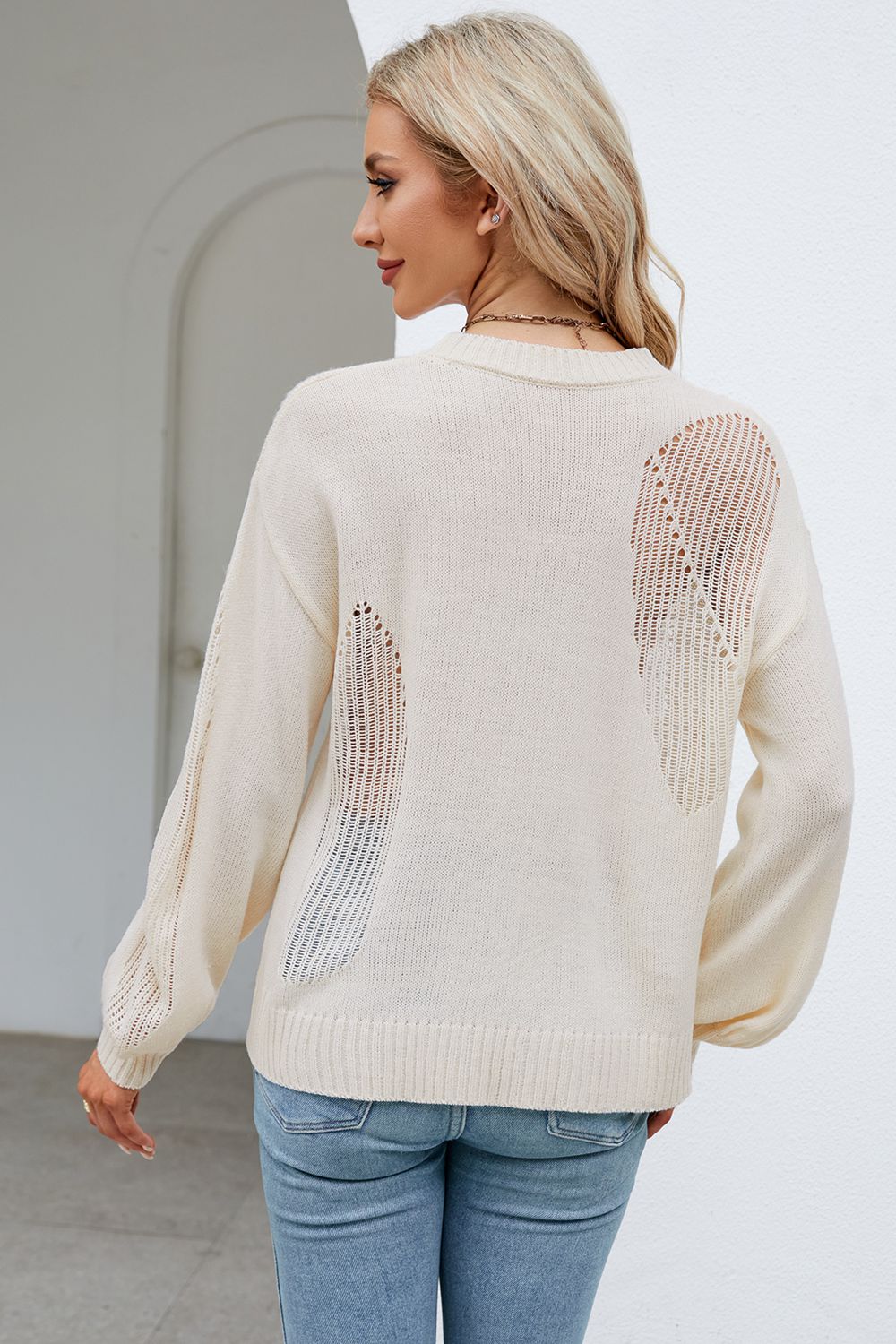Cream knit sweater with open slit details on back and sleeves.