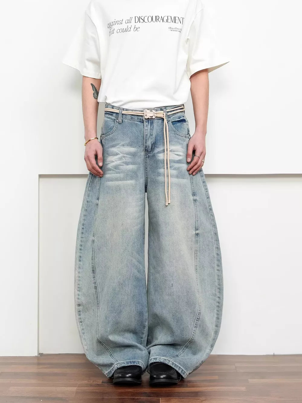 Belted wide leg jeans in light blue denim with a balloon silhouette.