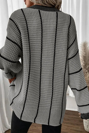 Gray knit oversized V-neck dress with black vertical stripes and waffle texture.