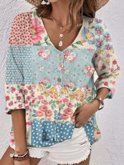 Printed V-neck blouse with floral and polka dot patchwork in light blue and cream, button front.
