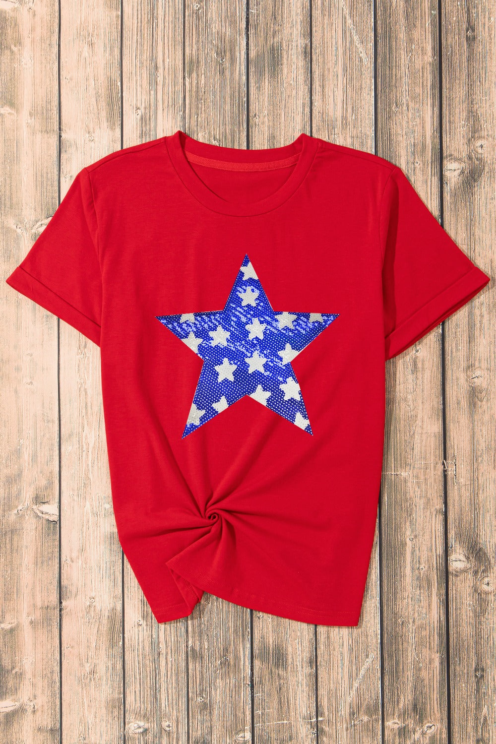 Red cotton blend t-shirt with a blue and white star graphic and a knotted hem.
